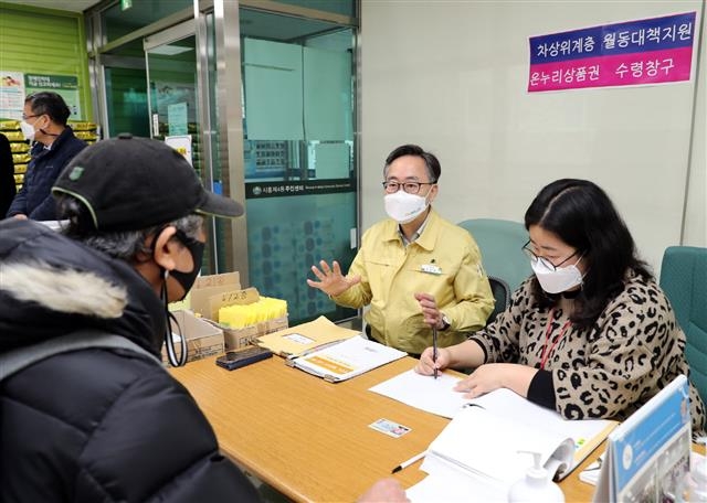 유성훈(가운데) 서울 금천구청장이 지난 22일 시흥4동 주민센터에서 차상위계층 월동대책비를 신청하러 온 주민과 상담하고 있다. 금천구 제공