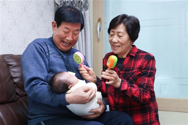 LG의인상을 수상한 전옥례(오른쪽·74)씨가 남편 유성기(73)씨와 함께 서울 서대문구의 자택에서 위탁아동을 돌보고 있다. LG 제공