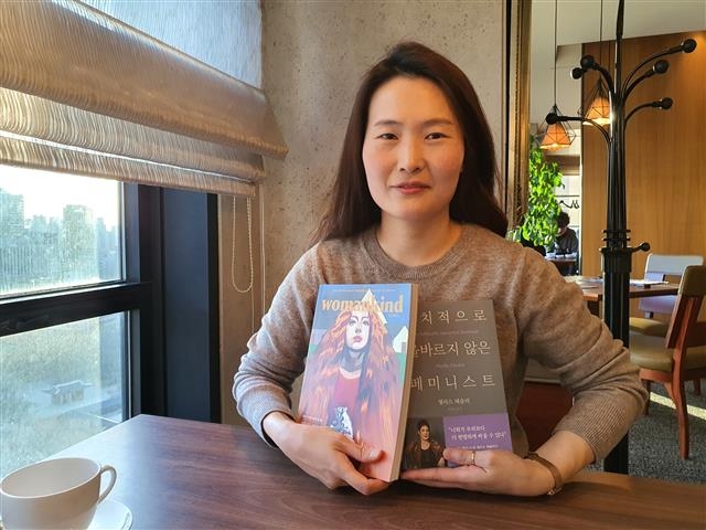 나희영 바다출판사 편집자가 자신이 편집한 잡지 ‘우먼카인드’와 책 ‘정치적으로 올바르지 않은 페미니스트’를 들어 보이고 있다.