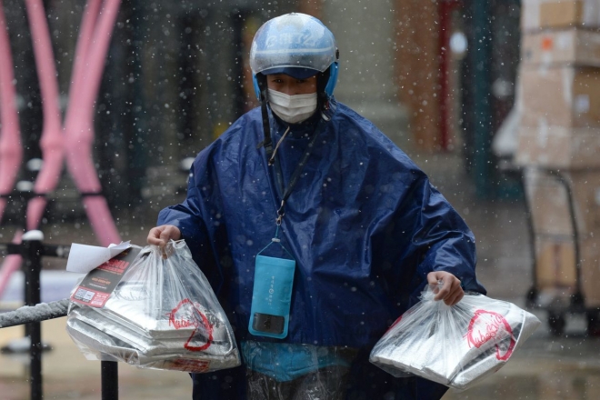 중국 알리바바그룹의 음식 배달 플랫폼 ‘어러머’의 한 노동자가 베이징에서 눈보라를 헤치고 주문 음식을 운반하고 있다. 베이징 로이터 연합뉴스