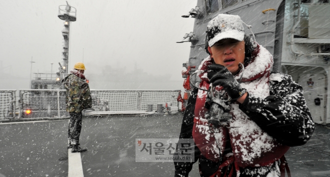 눈이 내리는 가운데 구축함 정박 작업을 하는 대원들. 해군 제공
