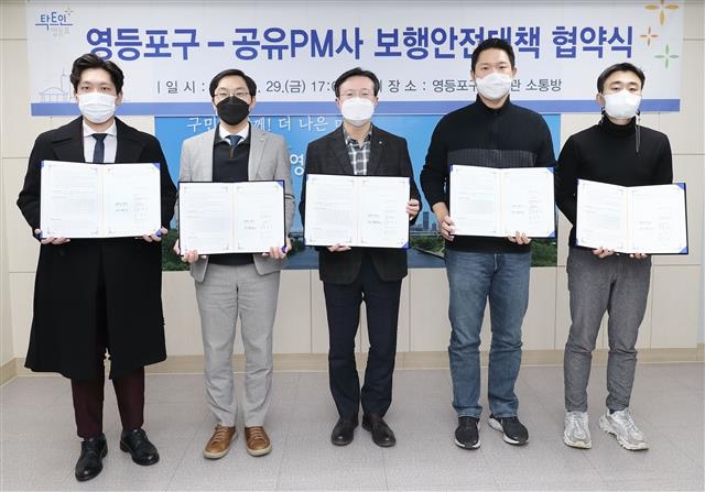 채현일(가운데) 서울 영등포구청장이 지난달 29일 구청 본관 3층 소통방에서 퍼스널 모빌리티 공유서비스 업체 4곳의 대표들과 전동 킥보드 보행안전대책 확립을 위한 협약서에 서명한 뒤 기념사진을 찍고 있다. 영등포구 제공
