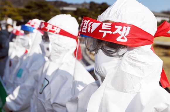 전국보건의료산업노동조합원들이 2일 서울 종로구 청와대 분수대 앞에서 보건의료노조 투쟁선포 기자회견을 열고 코로나19 전담병원 정원 확대, 인력기준 마련, 형평성 있는 지원체계 마련, 공공의료 강화를 촉구하며 머리띠를 두르고 있다. 2021. 2. 2 박윤슬 기자 seul@seoul.co.kr