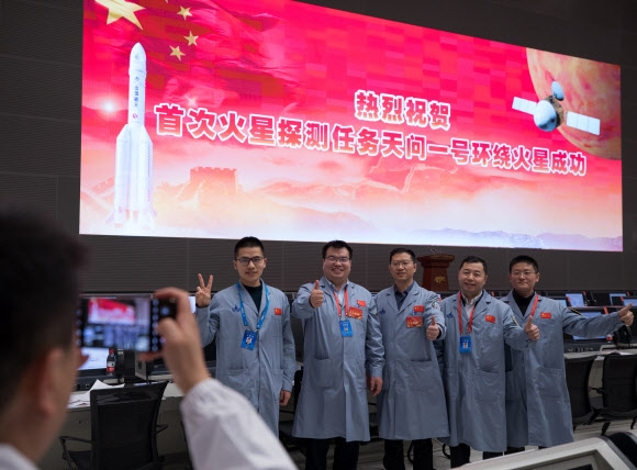 베이징에 있는 중국 국가우주국(CNSA) 우주통제센터 기술요원들이 10일 화성 탐사선 톈원 1호가 화성 궤도에 진입한 뒤 기념촬영을 하며 웃고 있다. 베이징 신화 연합뉴스 