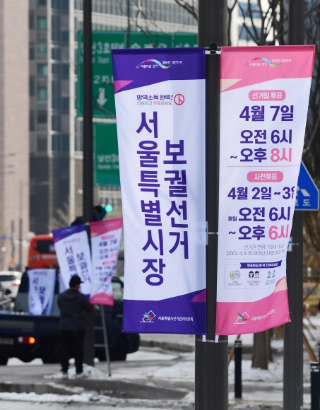 4·7 재·보궐선거를 50일 앞둔 16일 오후 서울 중구 서울시청 앞 도로변에서 서울시선관위 직원들이 ‘D-50‘ 가로등 현수기를 게시하고 있다. 선관위는 유권자의 투표참여를 독려하기 위해 세종대로 등 도심에 280여 개의 가로등 현수기를 게시했다.2021. 2. 16 박윤슬 기자 seul@seoul.co.kr