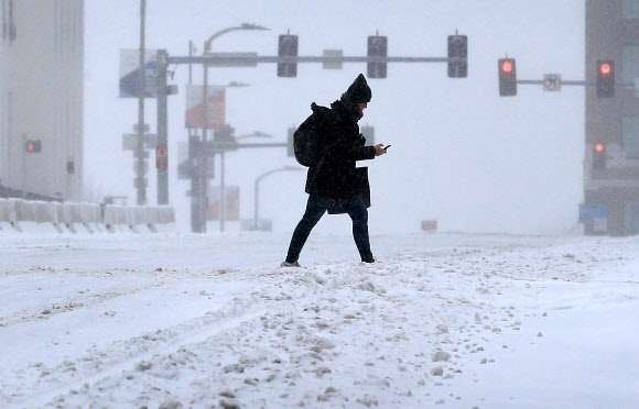 ‘겨울 폭풍’으로 폭설 내린 시내 걷는 미 미주리주 주민
