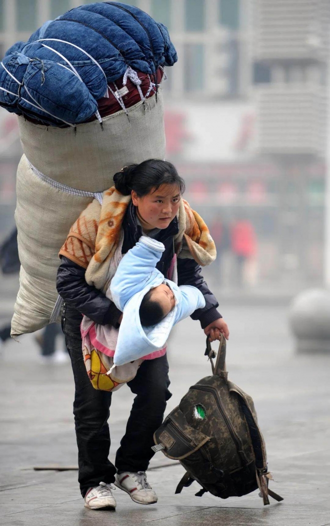 2010년 1월 30일 중국 장시성 난창역에서 신화통신 기자가 촬영한 ‘아가야, 엄마가 고향으로 데려다 줄 거야’라는 제목의 사진. 가난을 원망하지 않는 듯한 얼굴 표정이 많은 중국인들을 울렸다. 지금도 이 사진은 ‘가난 및 빈곤퇴치의 상징’으로 회자된다. 신화통신 제공