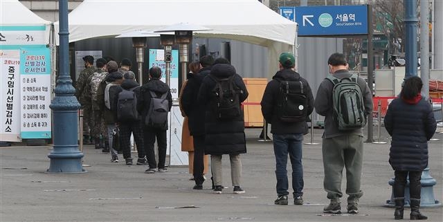 24일 오전 서울 중구 서울역 광장에 마련된 임시선별검사소에서 시민들이 코로나19 진단 검사를 받기 위해 길게 줄을 서 차례를 기다리고 있다. 2021.2.24 뉴스1
