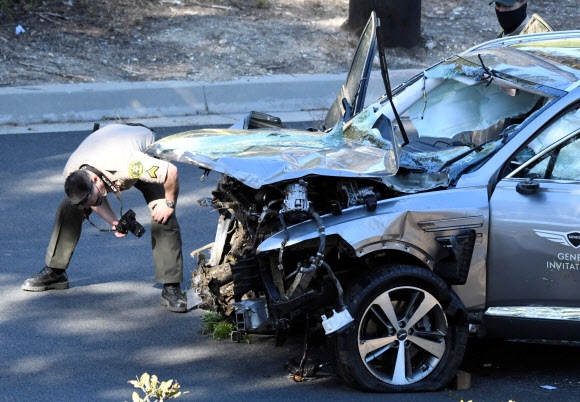 LA 카운티 보안관들이 23일(현지시간) 미국 캘리포니아주 로스앤젤레스에서 발생한 ‘골프 황제’ 타이거 우즈의 자동차 전복 사고 현장에 출동해 사고차량인 ‘제네시스 GV80’ 조사를 벌이고 있다.  로이터 연합뉴스
