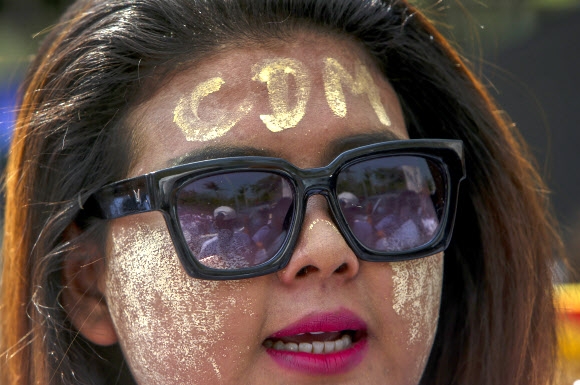 25일 미얀마 만달레이에서 쿠데타 저항 시위의 한 참가자가 전통화장품 ‘타나카’를 이용해 이마에 시민불복종운동을 뜻하는 ‘CDM’을 그린 채 구호를 외치고 있다. 만달레이 AP 연합뉴스