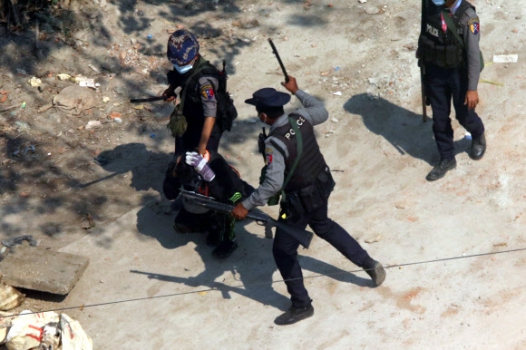 미얀마 경찰이 6일(현지시간) 양곤의 한 거리에서 군부 쿠데타 규탄 시위를 진압하는 과정에서 시위대를 구타하고 있다. AP 연합뉴스