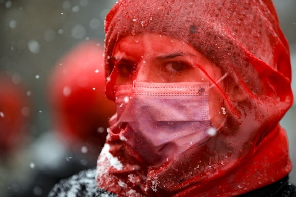 붉은색 베일은 쓴 여성이 10일(현지시간) 루마니아 부쿠레슈티에서 코로나19 대유행이 시작된 후 여성 폭력이 늘어난 것을 항의하는 시위를 벌이고 있다. AP 연합뉴스