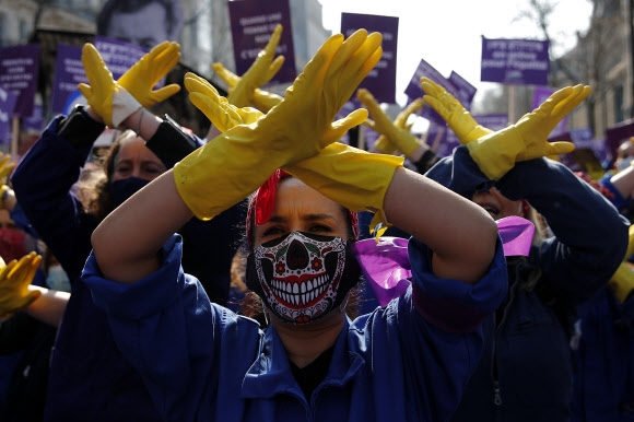 8일(현지시간) 프랑스 파리에서 시민들이 여성에 대한 차별과 폭력을 반대하는 시위를 벌이며 노란 고무장갑을 끼고 엑스(X) 표시를 그리는 퍼포먼스를 하고 있다. 파리 AP 연합뉴스