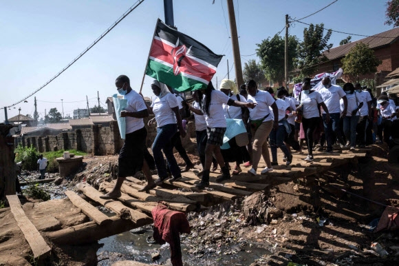 8일(현지시간) 케냐 나이로비의 슬럼가인 키베라에서 인권 활동가들이 세계 여성의날을 맞아 행진하고 있다. 나이로비 AFP 연합뉴스