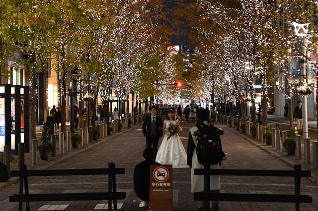 일본 도쿄도 지요다구 마루노우치 거리에서 결혼을 앞둔 커플이 야간 웨딩 촬영을 하고 있다.