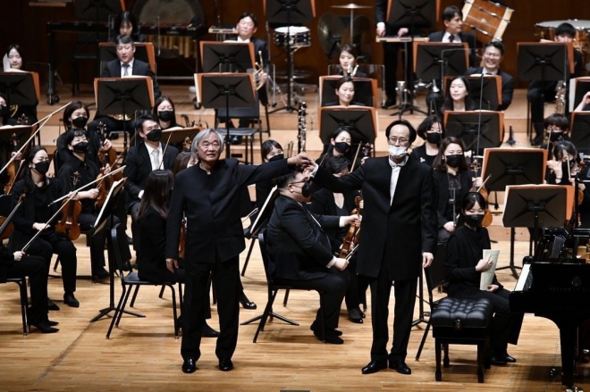 피아니스트 백건우(왼쪽)이 14일 서울 예술의전당 콘서트홀에서 코리안심포니오케스트라와 ‘백건우 버르토크 협주곡’을 협연한 뒤 최희준 지휘자와 손을 잡고 인사하고 있다. 빈체로 제공