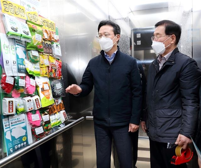 지난 11일 채현일(왼쪽) 영등포구청장이 당산로에 있는 한 아파트 엘리베이터 안에 부착된 소통 게시물을 살펴보고 있다. 영등포구 제공