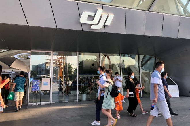 미국의 제재와 공매도 보고서 파문 등으로 중국의 드론 산업이 휘청거리고 있다. 사진은 지난해 8월 중국 광둥성 선전시에서 마스크를 낀 시민들이 DJI 매장 앞을 지나는 모습. 선전 로이터 연합뉴스