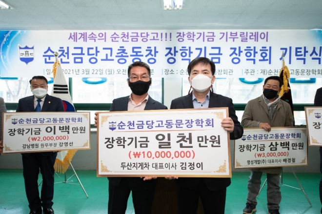김정이(4회·왼쪽) 두산지게차 대표가 김광수 장학회 이사장에게 1000만원을 기탁하고 있다. 