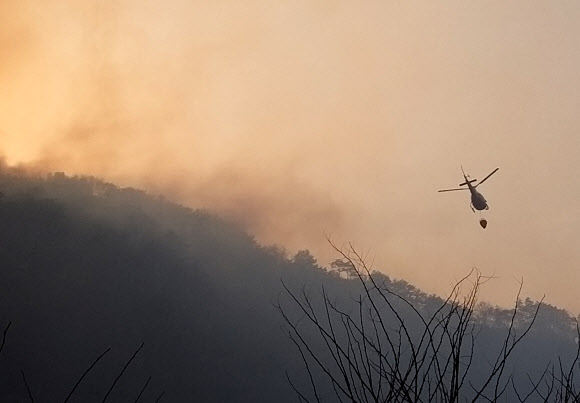 23일 오후 강원 홍천군 화촌면에서 산불이 나 산림당국이 헬기를 투입해 진화작업을 벌이고 있다.  2021.3.23  <br>홍천군 제공