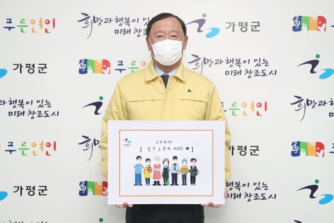 김성기 군수가 23일 노동자들을 응원하는 릴레이 캠페인에 동참 사진을 찍고 있다. 가평군 제공 