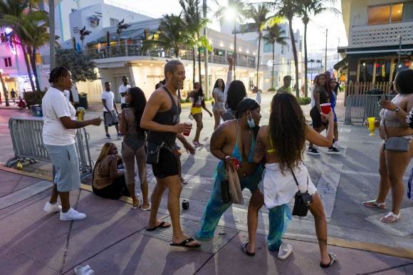 한 무리의 사람들이 22일 마이애미 해변에서 춤을 추고 있다. 연합뉴스