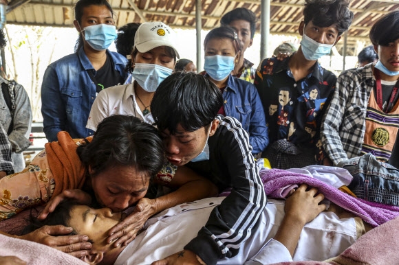 지난 22일(이하 현지시간) 미얀마에서 두 번째 큰 만달레이에서 군부 쿠데타에 항의하는 시위 도중 군경의 총탄에 맞아 숨진 &#48085; 뚠 뚠 아웅의 장례식이 다음날 열린 가운데 친구들이 마지막 작별을 하고 있다. 만달레이 EPA 연합뉴스 