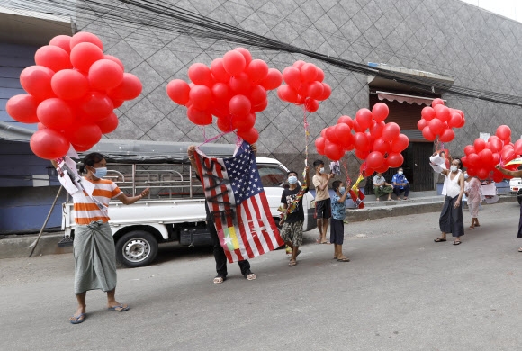 미얀마 군부 쿠데타를 규탄하는 미얀마인들이 24일 양곤에서 성조기와 빨간 풍선을 흔들며 미국을 비롯한 국제사회 개입을 촉구하고 있다. 양곤 EPA 연합뉴스