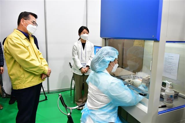 류경기(왼쪽) 서울 중랑구청장이 25일 ‘코로나19 예방접종센터’가 마련된 중랑문화체육관을 찾아 사전 모의 훈련을 진행하면서 백신 희석 과정을 살펴보고 있다. 중랑구 제공