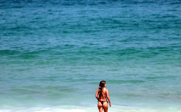 한 여성이 26일(현지시간) 브라질 리우데자네이루의 이파네마 해변에서 걷고 있다. EPA 연합뉴스