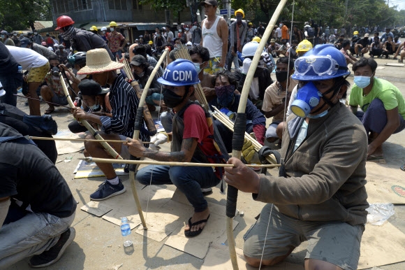 활 들고 시위 나선 시민들 반쿠데타 시위에 대해 무차별 총격이 이뤄지는 등 군경의 대응이 날로 격해지고 있는 가운데 ‘미얀마군의 날’이었던 지난 27일 미얀마 양곤에서 활을 든 시민들이 시위에 나섰다. 양곤 AP 연합뉴스