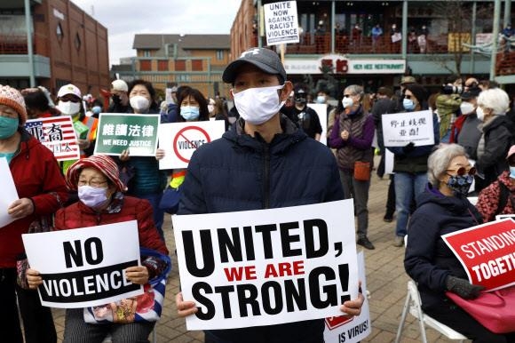 미국 일리노이주 시카고의 차이나타운에서 27일(현지시간) 열린 아시아계 혐오범죄 규탄 시위에서 한 남성이 ‘연대하는 우리는 강하다’라고 적힌 피켓을 들고 있다. 시카고 AP 연합뉴스