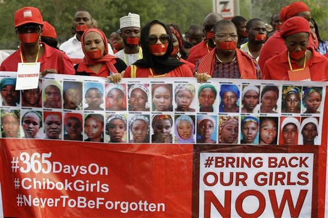 이슬람 무장 테러단체 보코하람이 나이지리아 치복에서 공립학교 여학생 276명을 한꺼번에 납치해 국제사회 공분을 일으킨 지 7년이 지났지만, 지난해 12월부터 나이지리아에서 몸값을 노린 학생 집단납치 사건이 다시 잇따르고 있다. 사진은 ‘치복 집단납치 사건’ 1년 뒤인 2015년 4월 13일 나이지리아 수도 아부자 거리에서 시민들이 치복 사건 피해자 사진을 새긴 플래카드를 들고 정부 대처를 촉구하는 침묵시위를 하고 있는 장면. 아부자 AP 연합뉴스