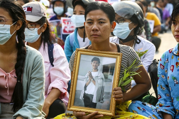 지난달 미얀마 만달레이에서 희생된 아들의 어머니가 1일 시위 도중 아들의 영정을 든 채 참가하고 있다. 만달레이 EPA 연합뉴스 