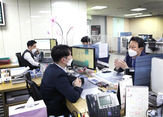 김광수(오른쪽) 은행연합회장이 5일 신한은행 성수동기업금융센터 영업점에서 직원으로부터 대출상환 유예 조치 시행 과정의 어려움에 대해 듣고 있다. 은행연합회 제공