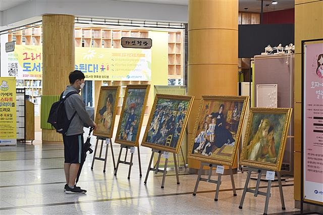 5일 서울 노원구 상계10동 노원정보도서관에 마련된 전시 공간에서 주민이 피에르 오귀스트 르누아르의 모작을 관람하고 있다. 노원구 제공