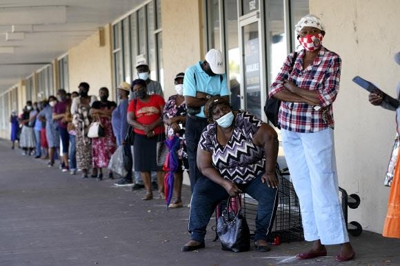 미국 시민들이 10일(현지시간) 코로나19 백신을 맞기 위해 플로리다주 이모컬리의 한 병원 앞에 줄을 서 있다. 이모컬리 AP통신