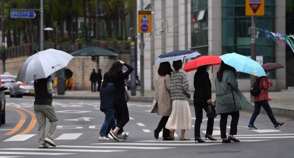 전국적으로 비가 내리는 12일 서울 시내에서 시민들이 우산을 쓰고 횡단보도를 건너고 있다. 2021.4.12 오장환 기자 5zzang@seoul.co.kr