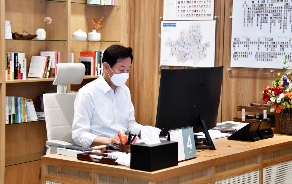오세훈 서울시장이 8일 서울시청으로 출근해 업무를 보고 있다. 오른쪽으로 서울시 공무원들의 취임 축하 꽃다발이 있다. 서울시 제공.