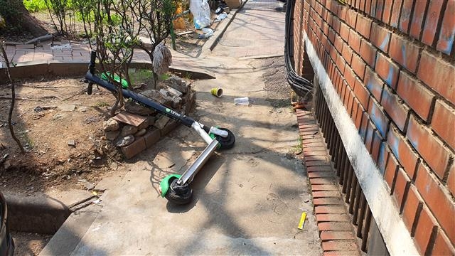 지난 11일 서울 양천구 한 아파트 단지 내 좁은 골목 한쪽에 전동킥보드가 쓰러진 채 방치돼 보행자의 통행을 방해하고 있다.