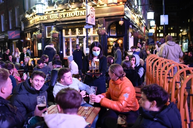 13일 영국 정부의 코로나 봉쇄 완화가 시작된 날 런던 소호의 한 야외 펍에서 사람들이 맥주를 즐기고 있다.AP 연합뉴스