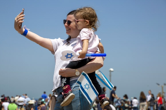 한 이스라엘 여성이 지난 15일(현지시간) 텔아비브에서 독립기념일 행사에 참석해 딸과 기념촬영을 하고 있다. AP 연합뉴스