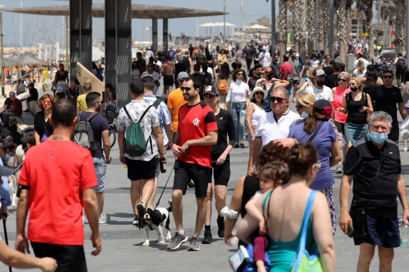 이스라엘 정부가 실외 마스크 착용 의무를 전면 해제하기 하루 전날인 17일(현지시간) 텔아비브 지중해변에서 시민들이 마스크를 벗어던진 채 한가로이 주말을 만끽하고 있다. 세계에서 코로나19 백신 접종률이 가장 높은 이스라엘이 마스크 착용을 해제한 것은 코로나19 팬데믹(대유행) 초기인 지난해 4월 1일 마스크 착용을 의무화한 지 1년여 만이다. 텔아비브 EPA 연합뉴스