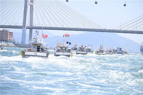 여수 어업인들이 19일 일본의 원전 오염수 해양방출 결정 규탄 대회 후 연·근해 어선 150여척을 동원해 해상 시위를 벌이고 있다.