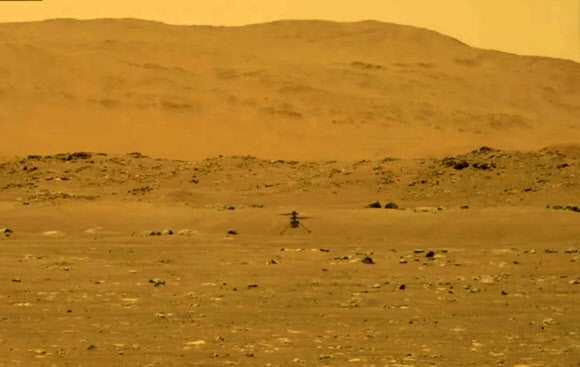 미국 항공우주국(NASA)의 화성 헬리콥터 인저뉴어티가 19일 화성 상공을 처음 비행 실험에 성공, 표면으로부터 3m 상공까지 올라 정지 비행을 하고 있다. NASA·제트추진연구소(JPL) 제공 로이터 연합뉴스 