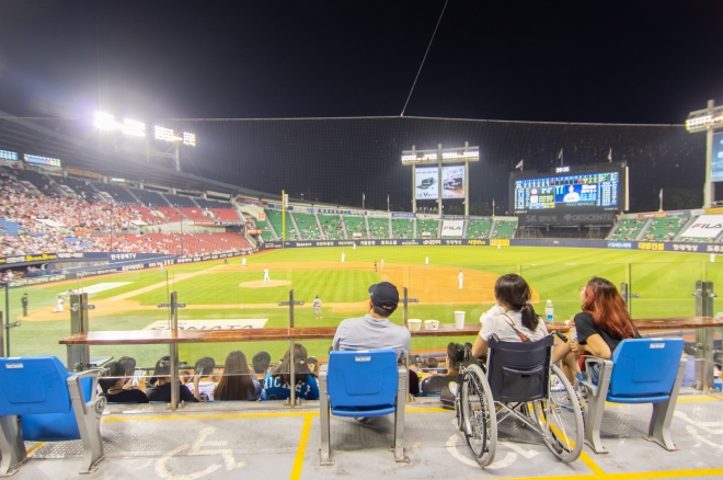 잠실구장 휠체어석에서 한 장애인 가족이 야구를 보는 모습.