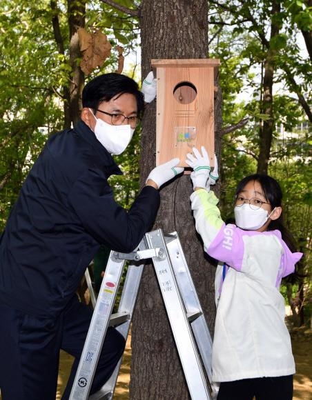 21일 서울 송파구 송파둘레길 장지근린공원에서 박성수(왼쪽) 송파구청장과 송파어린이명예기자 고예랑양이 나무에 인공 새집을 달고 있다. 박지환 기자 popocar@seoul.co.kr