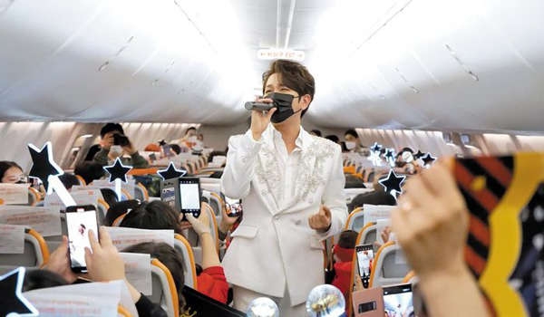 트로트 가수 김수찬이 기내 객석 통로에서 노래를 부르고 있다. 제주항공은 해당 행사를 ‘팬미팅’으로 신고하고 진행했다.  제주항공 제공