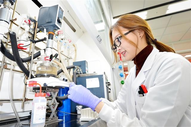 LG화학 미래기술연구센터 연구원들이 신규 개발한 생분해성 신소재의 물성을 테스트하고 있다.  LG화학 제공