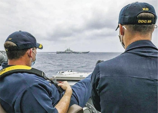 미 해군 유도미사일 구축함 USS 머스틴함 선상에서 지휘관 2명이 중국 인민해방군(중국군) 항공모함 랴오닝함이 항해하는 모습을 여유롭게 지켜보는 사진. 미 해군은 해당 사진 설명에서 동중국해상에서 머스틴함의 지휘관 로버트 브리그스 중령과 부지휘관인 리처드 슬리예 중령이 불과 수천 ｍ 떨어져 있는 랴오닝함을 지켜보는 모습이라고 밝혔다. 2021.4.11 미 해군 제공